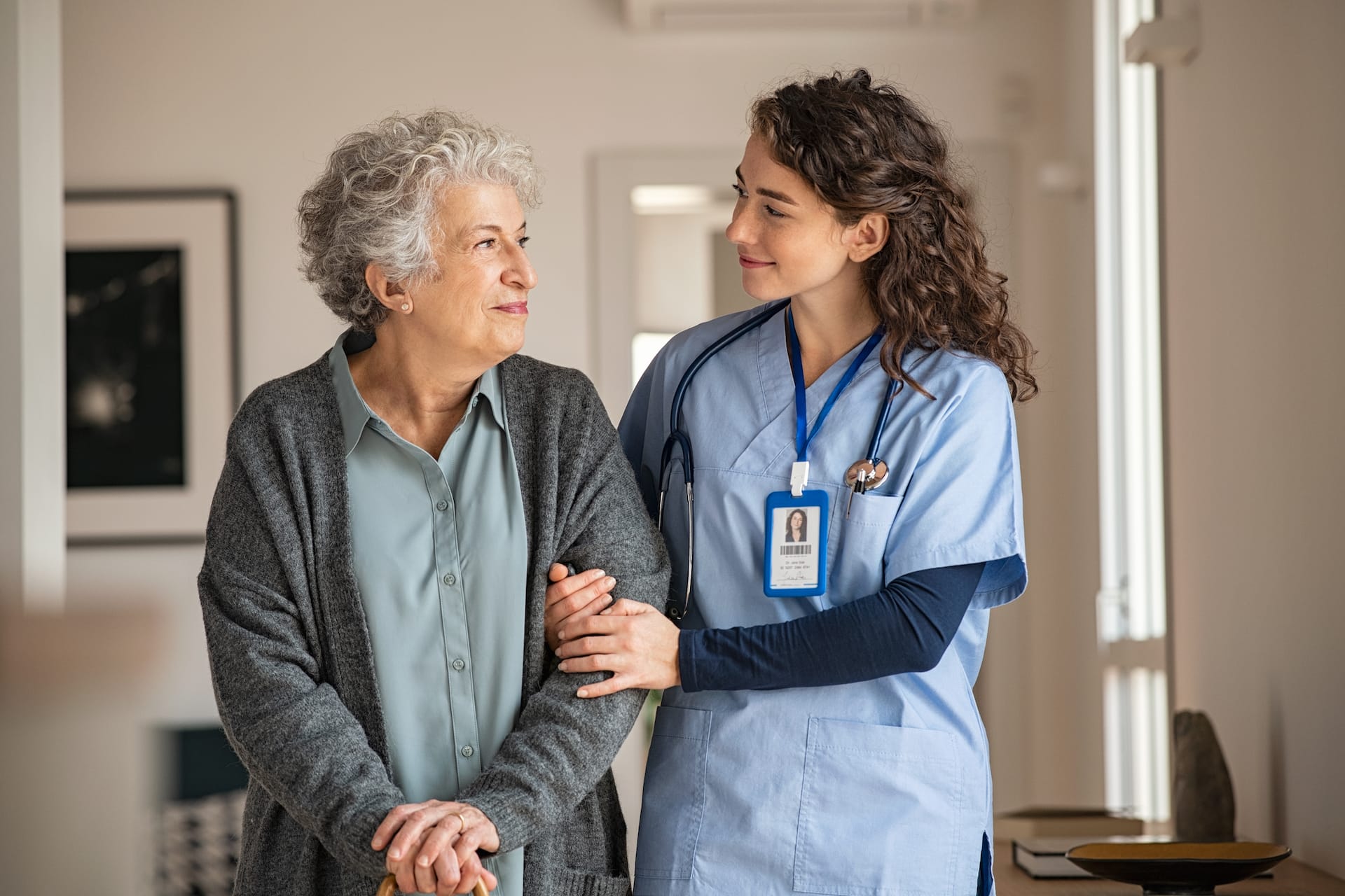 A nurse helping an elderly woman